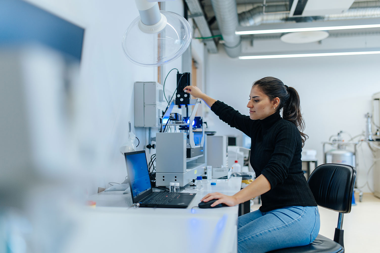 Eine Forscherin der FAU im Labor am Laptop.