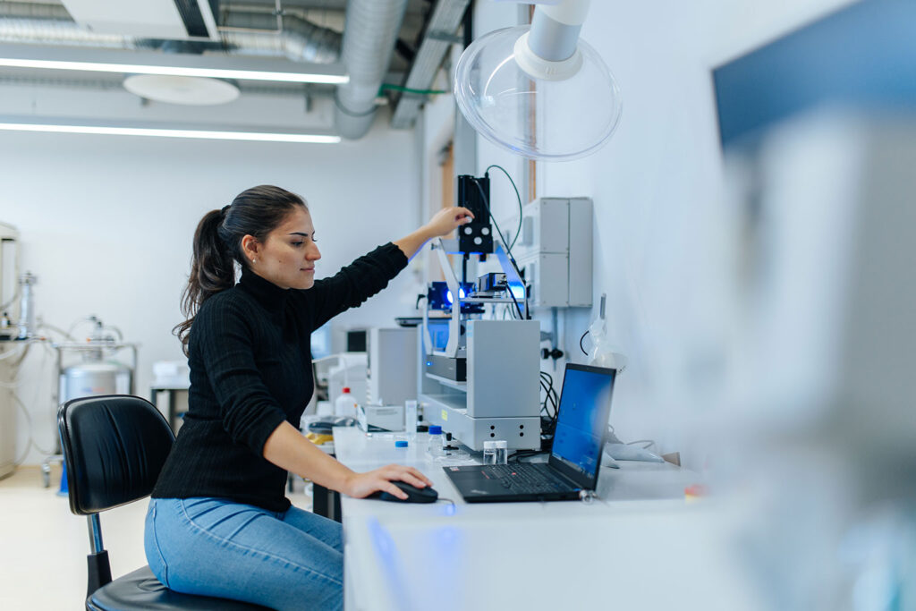 Eine Forscherin der FAU im Labor am Laptop.