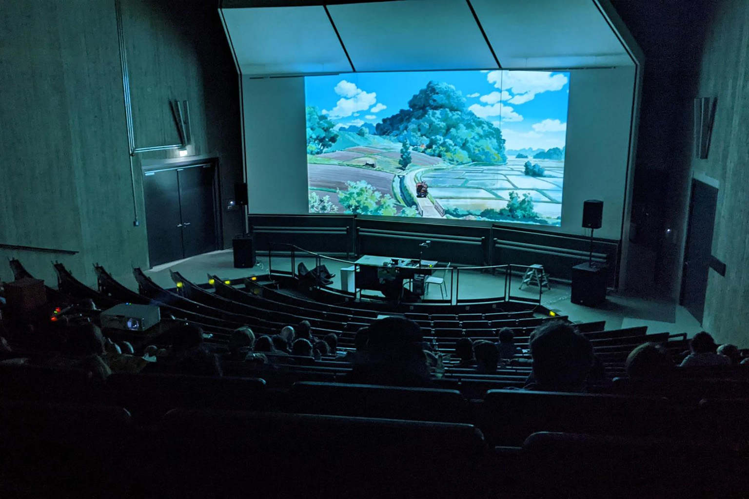 Ein Hörsaal im Dunkeln, ein Film auf der Leinwand.