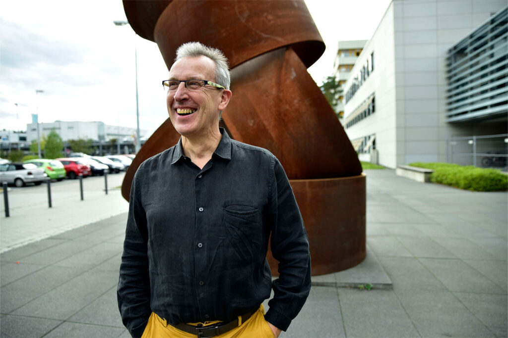 Photo of Enrique Zuazua in front of a statue.